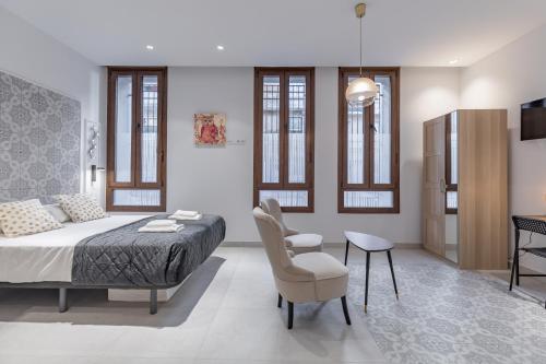 um quarto com uma cama, uma cadeira e uma mesa em Gorgeous Apartment close to City Centre em Valência