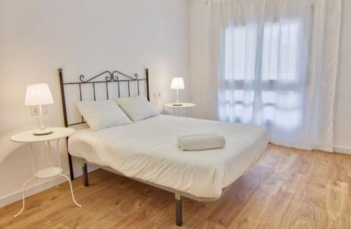 1 dormitorio con 1 cama blanca grande y 2 lámparas en Casa Antoniet de la llum, en Riumar