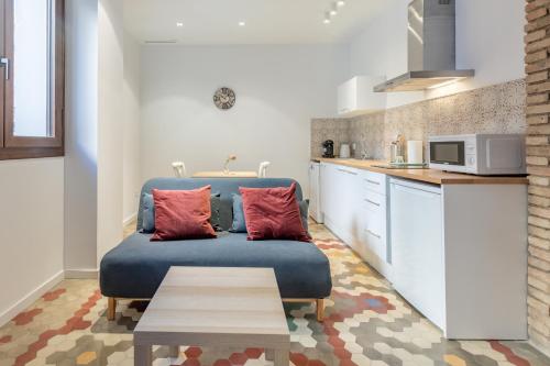 Apt with Antique Floor & lots of Sun Light في فالنسيا: غرفة معيشة مع أريكة زرقاء في مطبخ