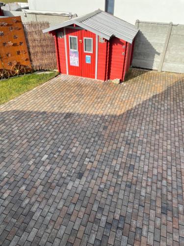 a red shed with a roof on a brick driveway at Luckylake in Muhr amSee