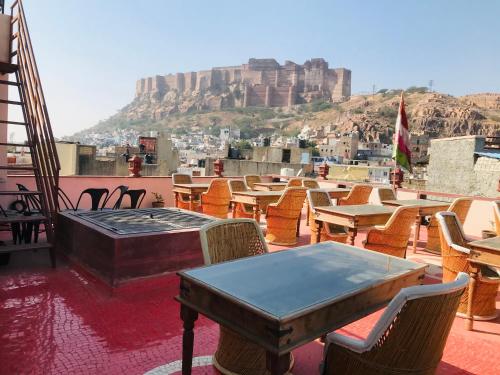 a table and chairs on a roof with a view ofhens at Corsican Haveli in Jodhpur