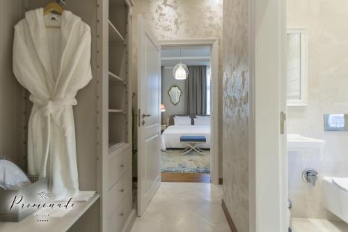 a white bathroom with a tub and a bedroom at Villa Promenade in Burgas City