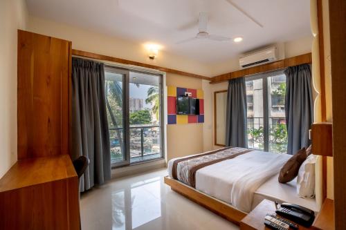 Home2 Suites and Service Apartments, Mumbai Airport في مومباي: غرفة نوم بسرير ونوافذ