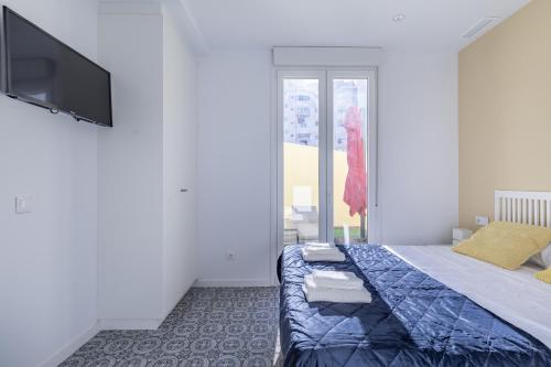 Marvellous Apt with a Large Private Terrace في فالنسيا: غرفة نوم بسرير وتلفزيون بشاشة مسطحة
