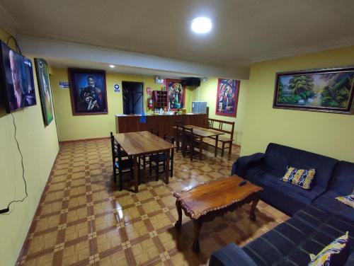 un soggiorno con divano blu e tavolo di Hostel Las Gardenias Ayacucho ad Ayacucho