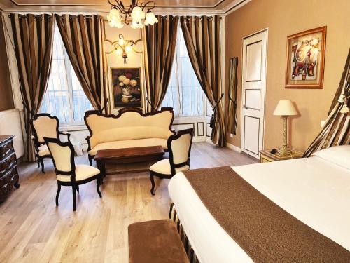 a bedroom with a bed and a table and chairs at Hotel De La Poste in Langres