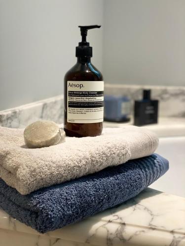 une bouteille de savon posée sur une pile de serviettes dans l'établissement Luxury villa in Cannes with swimming pool & sea view, à Cannes