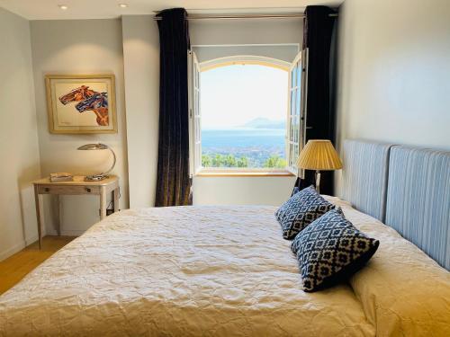 une chambre avec un lit avec une grande fenêtre dans l'établissement Luxury villa in Cannes with swimming pool & sea view, à Cannes