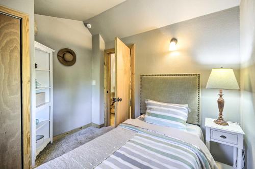 a small bedroom with a bed and a lamp at Pet-Friendly Cabin Minutes to Gig Harbor! in Fox Island