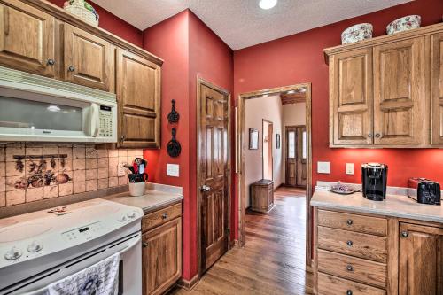 a kitchen with red walls and wooden cabinets at Pet-Friendly Abingdon Abode with Yard and Grill! in Abingdon