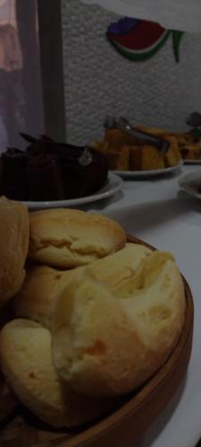 a plate of bread on a table with plates of food at Pousada Rota das Águas in Nobres