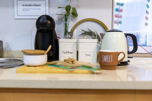 a kitchen counter with a coffee maker and coffee cups at Aguda Beach Porto, Slow Travel Houses in Vila Nova de Gaia