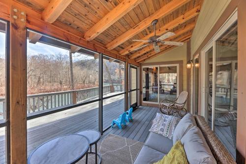a screened porch with a couch and a ceiling fan at Serenity on the River Luxe Lewisburg Cabin! in Lewisburg