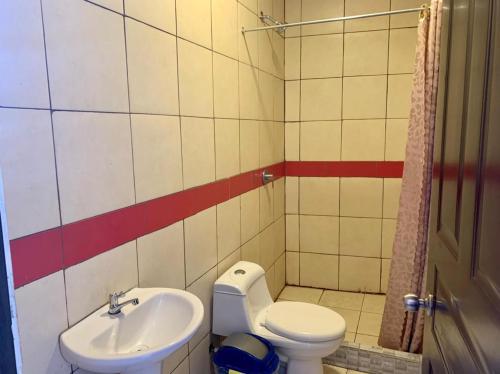 a small bathroom with a toilet and a sink at La Fortuna Roja in San José