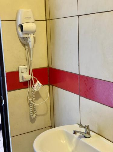 a bathroom with a sink and a phone on the wall at La Fortuna Roja in San José