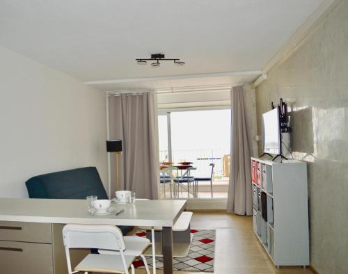 une cuisine et une salle à manger avec une table et des chaises dans l'établissement LE PEARL - La grande motte 1er ligne vue mer - climatisation et parking, à La Grande Motte