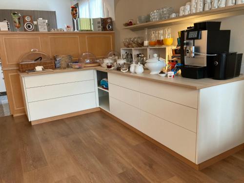 a kitchen with white cabinets and a counter at Garni Villa Siesta Park in Losone