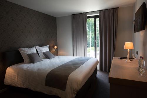 a hotel room with a large bed and a window at Hotel De Lissewal in Ieper