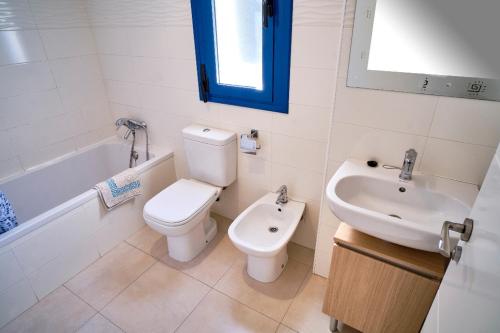 a white bathroom with a toilet and a sink at Magnifico Apartamento Edificio Marina in Calafat