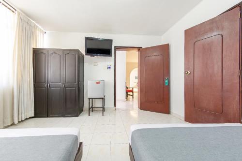 a bedroom with two beds and a flat screen tv at Imperio la 16 in Pereira