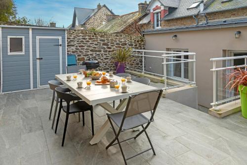 un patio avec une table et des chaises sur un balcon dans l'établissement BISLAYNE, à Saint-Malo