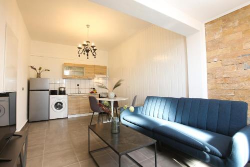 a living room with a blue couch and a table at Luxury Apartments Christos in Gouvia