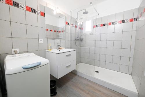 une salle de bain blanche avec un lavabo et une baignoire dans l'établissement Magnifique 3 pièces, à Port-Vendres