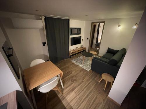 een woonkamer met een bank en een tafel bij Le gîte cozy de Bouvacôte avec vue panoramique in Le Tholy