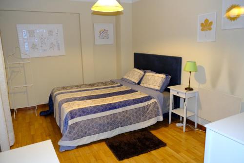 a small bedroom with a bed and a lamp at Apartamento Alegria in Arouca