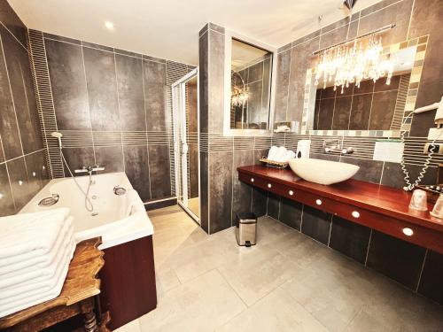a bathroom with a tub and a sink and a bath tub at Hotel De La Poste in Langres