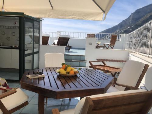 a table with a bowl of fruit on a balcony at Infinity Sea View House in Amalfi