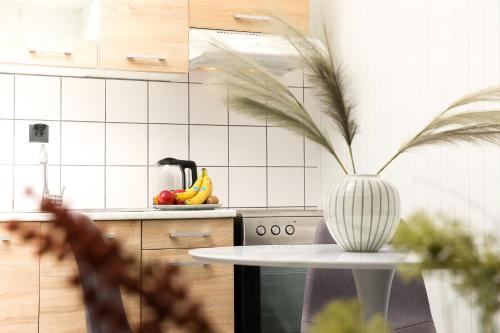 a kitchen with a table and a vase on a counter at Luxury Apartments Christos in Gouvia