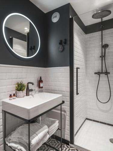 a bathroom with a sink and a mirror at Maisons du Monde Hotel & Suites - Nantes in Nantes