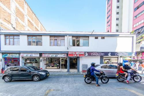 a group of people riding motorcycles on a city street at Imperio la 16 in Pereira