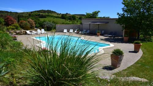 a swimming pool in a yard with chairs and a building at Cabanes Trésors de Campagne,spas privatifs in Villarzel-du-Razès