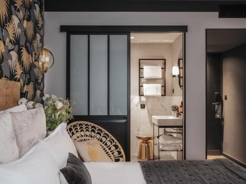 a hotel room with a bed and a bathroom at Maisons du Monde Hotel & Suites - Nantes in Nantes