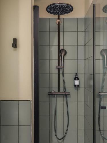 a shower with a shower head in a bathroom at Maisons du Monde Hotel & Suites - Nantes in Nantes