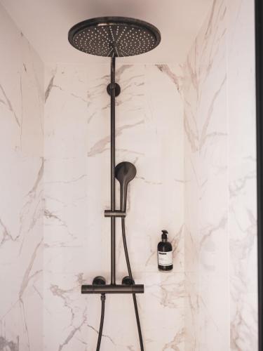 a black lamp in a bathroom with a marble wall at Maisons du Monde Hotel & Suites - Nantes in Nantes