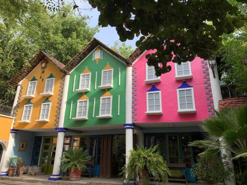a row of houses painted in different colors at Hotel La Casa de los Árboles Immersive Experience in Zacualpan de Amilpas