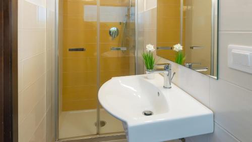 y baño con lavabo y ducha. en Welcomely - Waterfront home a balcony on the sea, en Alghero