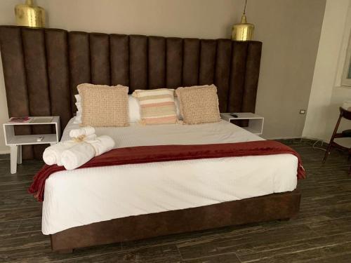 a bedroom with a large bed with towels on it at Casa Martha hotel boutique in Tequisquiapan