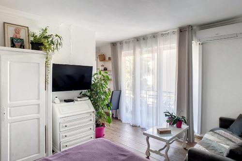 uma sala de estar com televisão numa cómoda branca em HENRI CAMILLE REAL ESTATE - CARNOT - Nice studio 8min Palais em Cannes