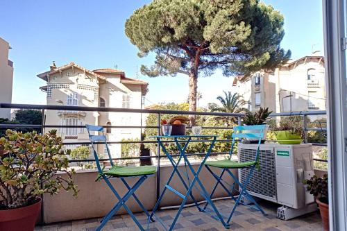 uma varanda com duas cadeiras e uma árvore em HENRI CAMILLE REAL ESTATE - CARNOT - Nice studio 8min Palais em Cannes