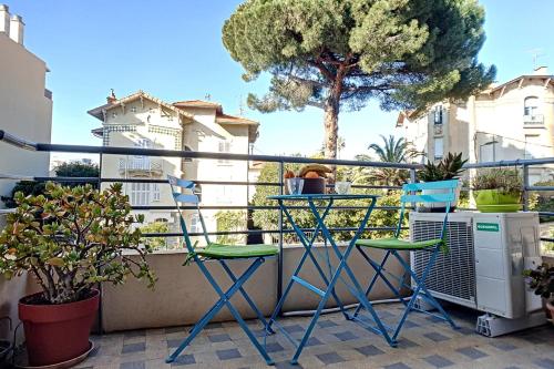 a balcony with two chairs and a tree at HENRI CAMILLE REAL ESTATE - CARNOT - Nice studio 8min Palais in Cannes