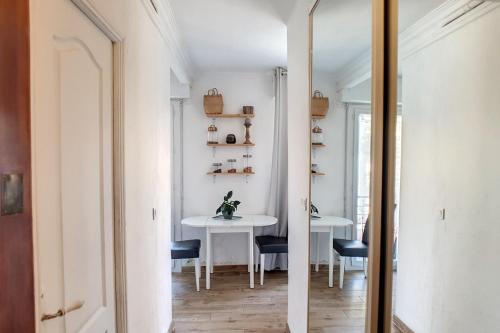 a hallway with a table and chairs and a mirror at HENRI CAMILLE REAL ESTATE - CARNOT - Nice studio 8min Palais in Cannes