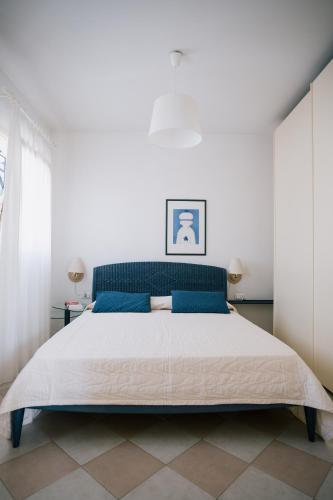 a bedroom with a large bed with blue accents at Villa Carlotta Jesolo Lido in Lido di Jesolo