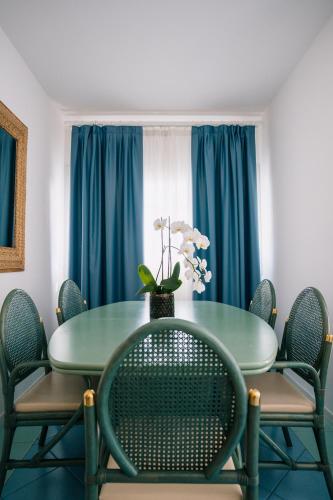 a dining room with a green table and chairs at Villa Carlotta Jesolo Lido in Lido di Jesolo