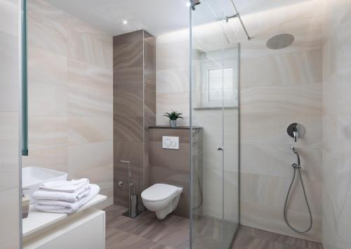 a bathroom with a toilet and a glass shower at Elais Luxury Residence in Podstrana