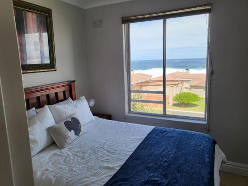 a bedroom with a bed with a view of the ocean at Hermanus Beach Club in Hermanus