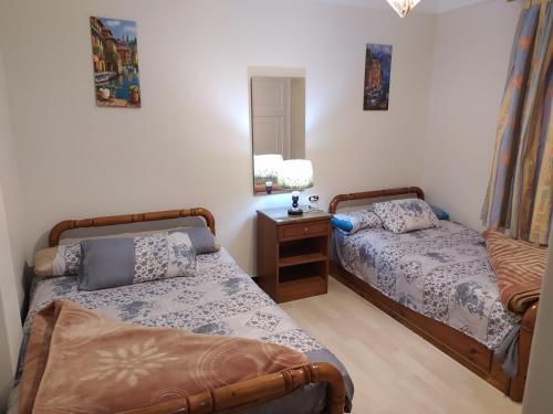a bedroom with two beds and a table with a mirror at Maamoura Beach Zahraa Apartment 9/206 in Alexandria